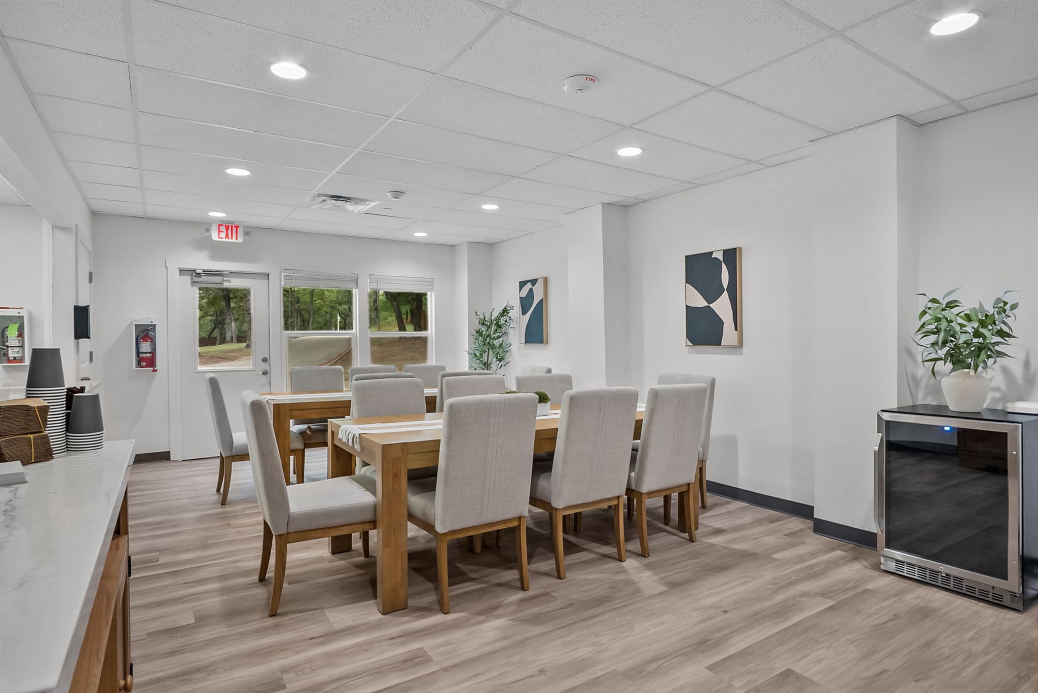 Dining table set beneath large windows